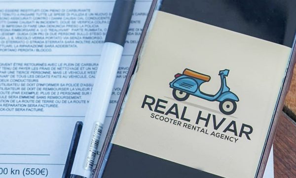 a photo of a logo from Real Hvar rental agency on a phone with the contract in the background